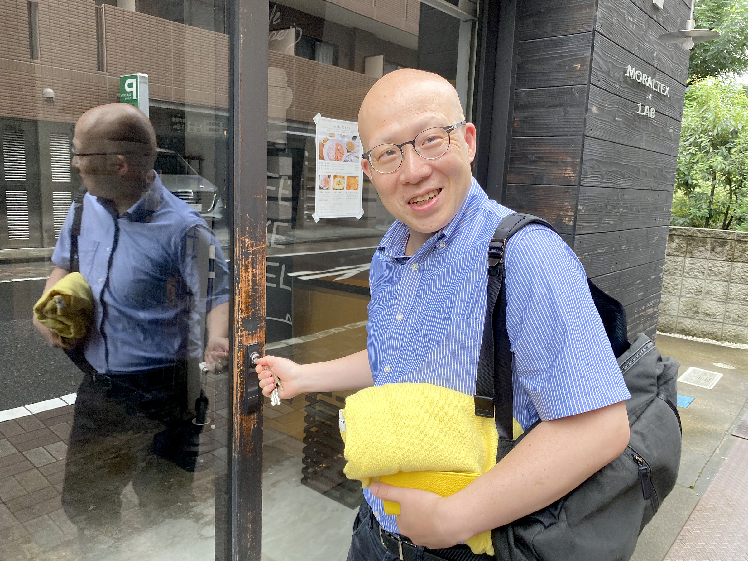 タオルを抱えて店先に立つ鳥山さん