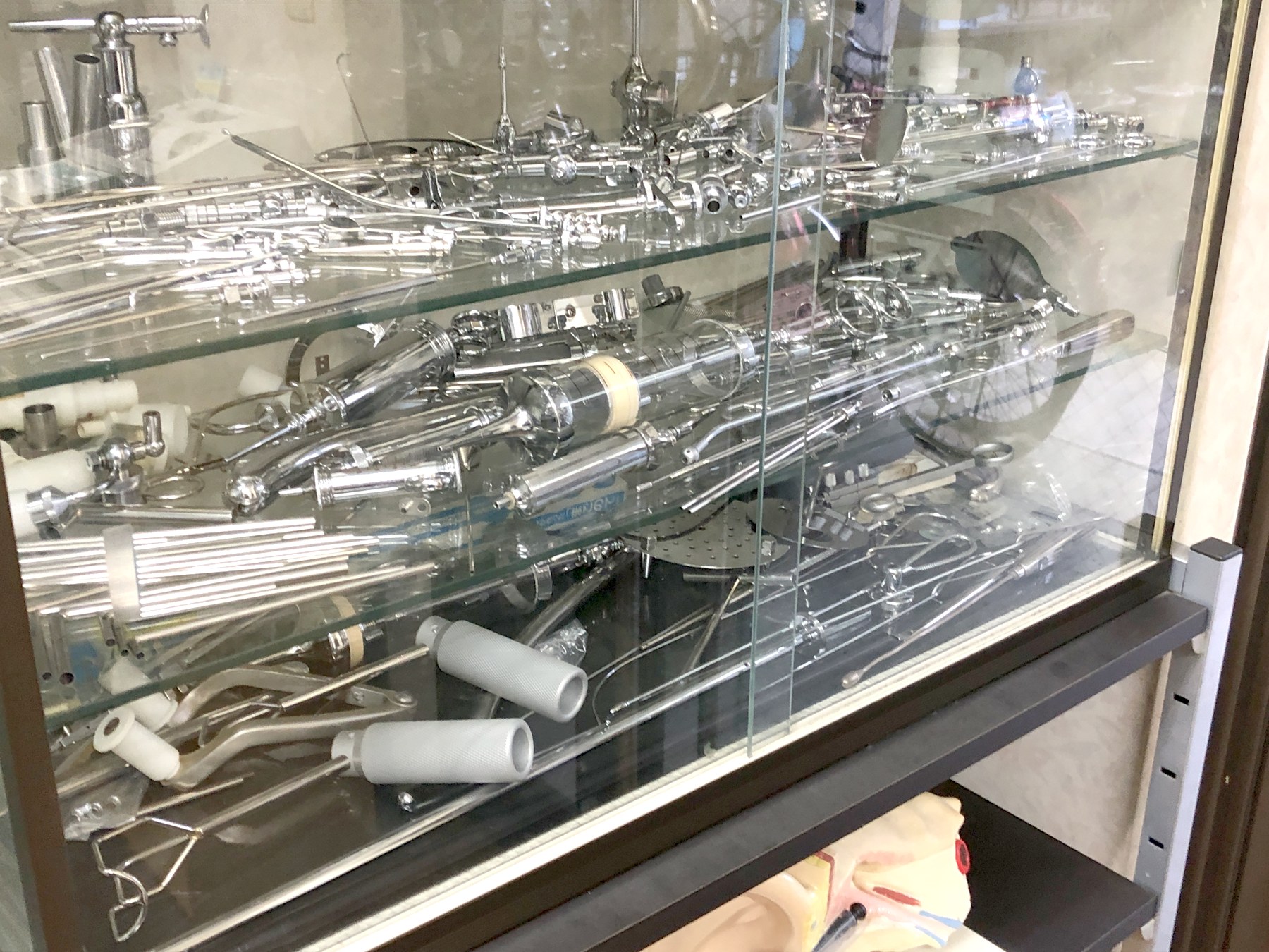 ガラスケースに並ぶ、三祐医科工業がつくってきた金属製の医療器具