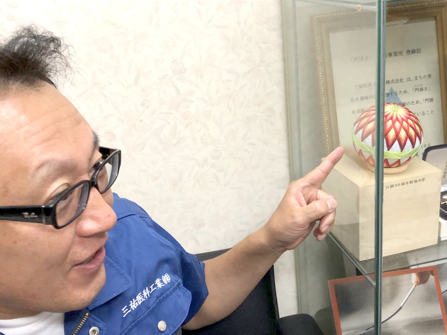 ガラスケースの展示品を指さして説明する小林さん