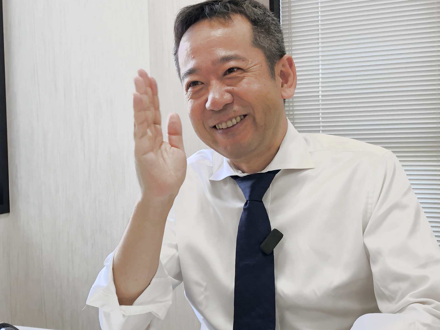 笑顔で手を上げて話す宋さん